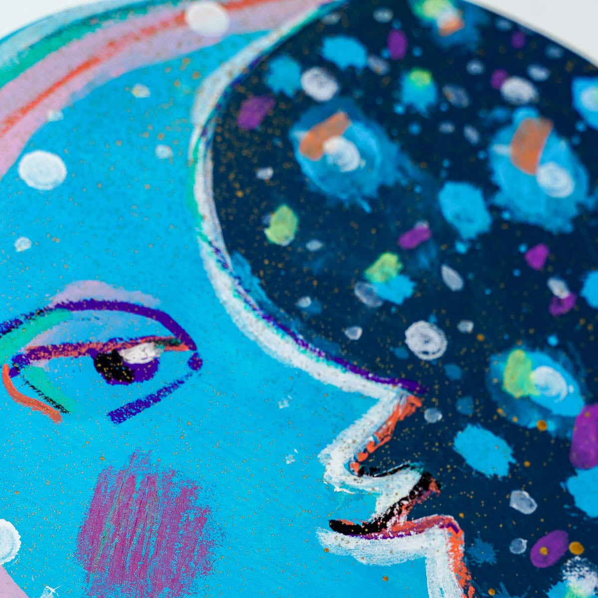Colorful abstract painting of a moon face with a blue background