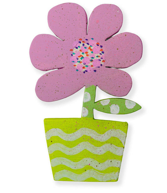 Wooden cut out artwork of a flower with pink petals and a green pot on a white background